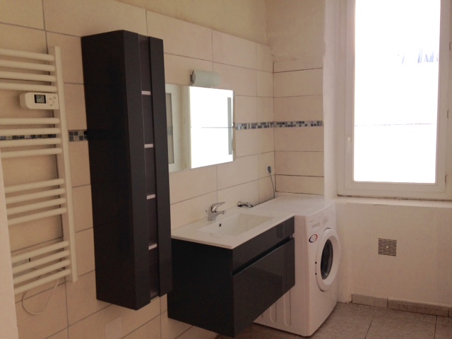 Une grande salle de bain, équipée du lave-linge.